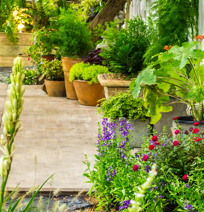 Terrasse die gepflastert ist und mit Blumentöpfen dekoriert ist.